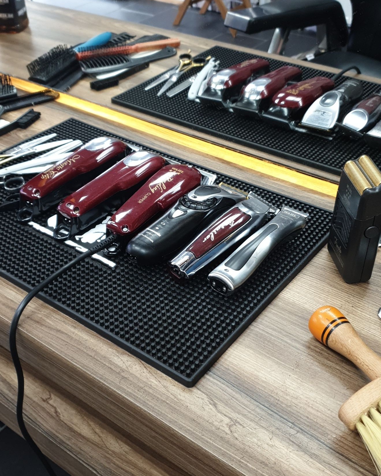 Tondeuses, trimmers en kammen op de mat van een kapstation bij Barber Labs